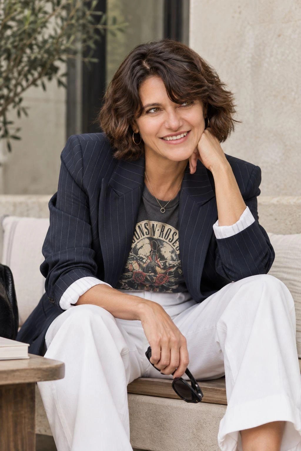 Bernardette M. seated, in a pinstripe blazer.